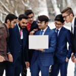 Young Indian businessmen analyzing GDP forecast and investment returns with currency symbols india economy