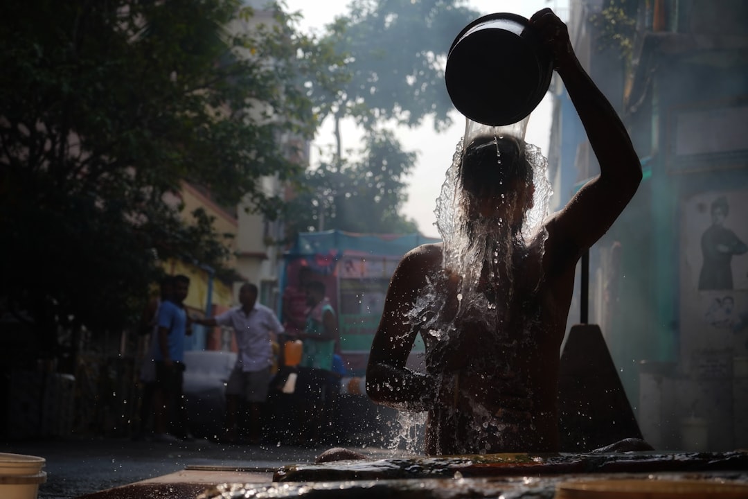 A young Indian woman touching her frizzy monsoon hair after stepping out in the rain on a humid June morning