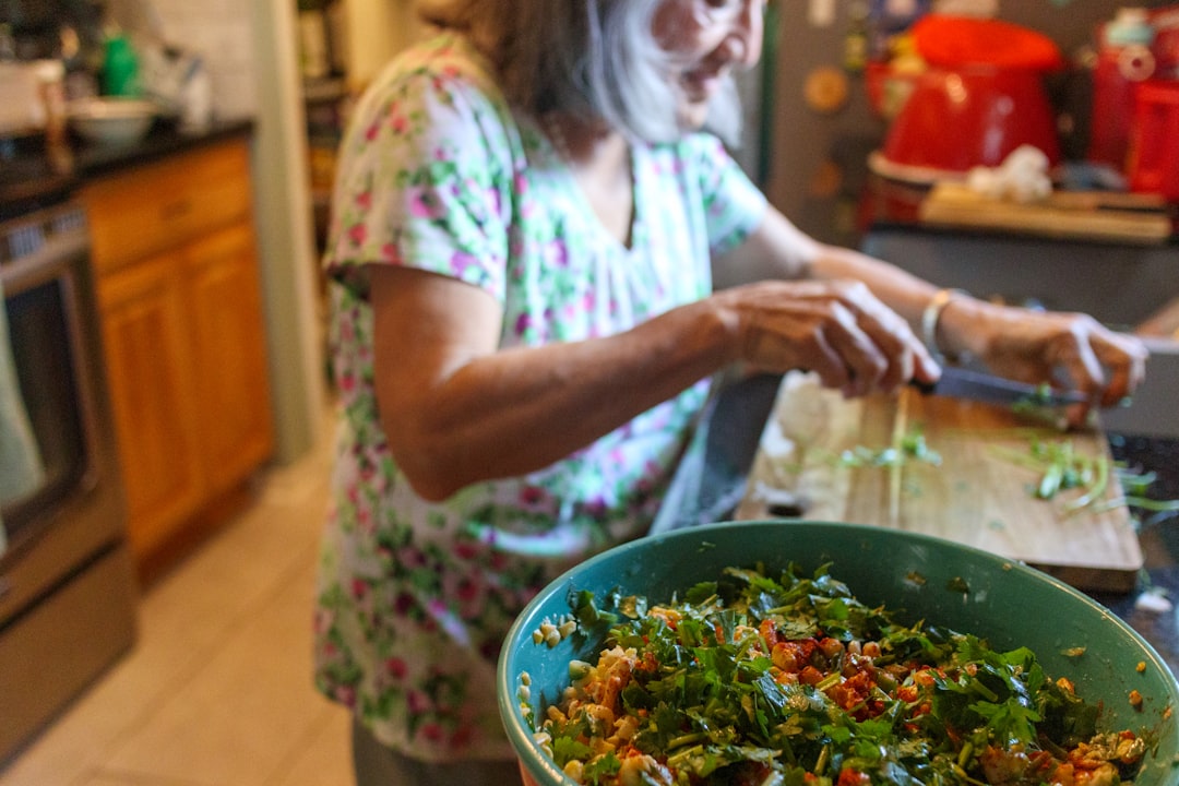 A young Indian woman sorting vegetable peels into a composting bin in her apartment kitchen