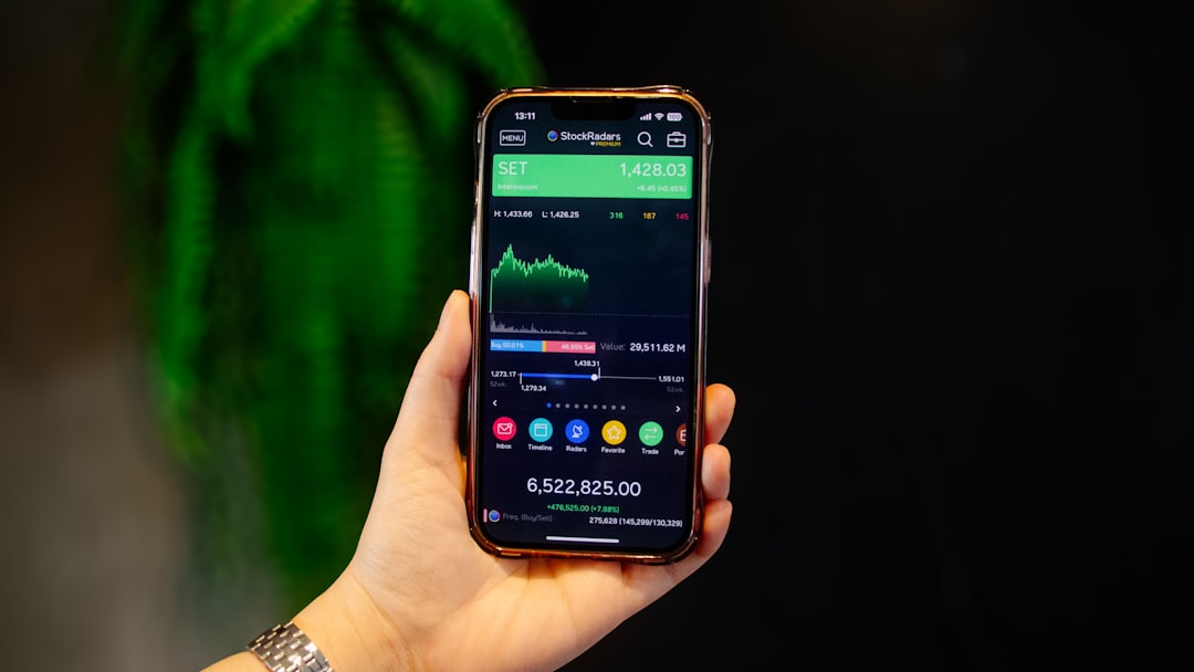 A young Indian woman checks her index funds portfolio on a smartphone at a modern desk