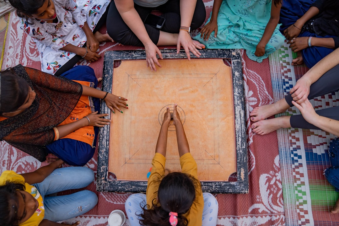 A grandmother teaches her grandchild how to play traditional Indian games on a wooden board at home