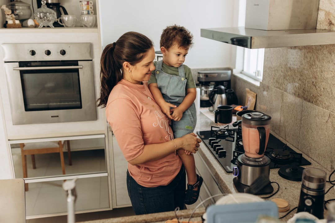 A mother and child performing science experiments at home using turmeric and bowls on a kitchen counter in India