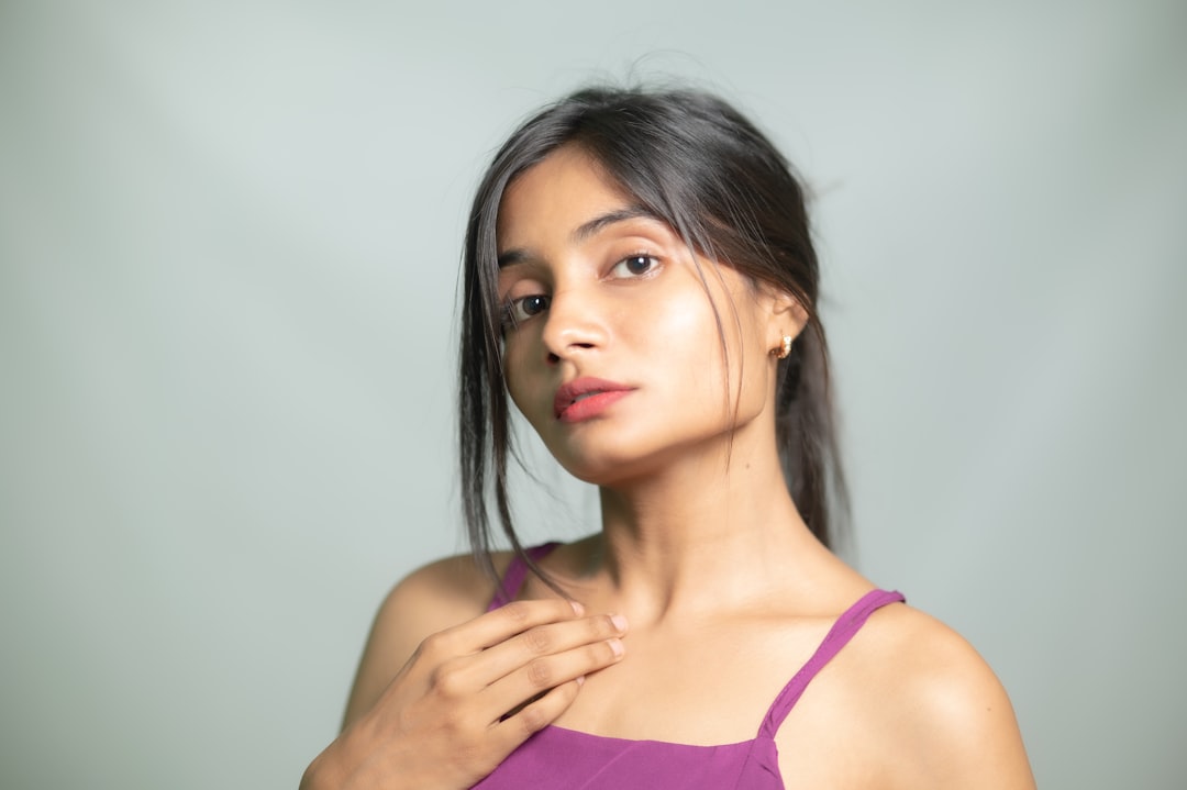 Young Indian woman applying a lightweight gel moisturizer as part of her monsoon skincare routine at home