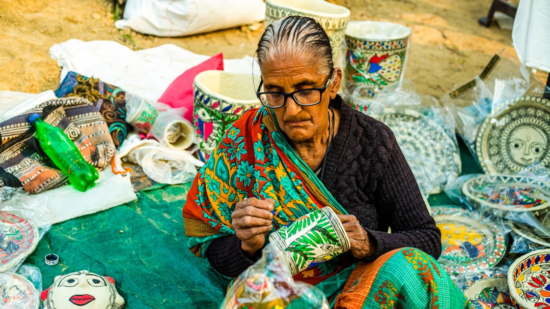 An Indian woman artisan reviewing handmade pricing beside her craft products