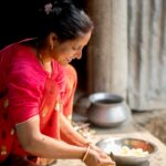 A woman in an Indian kitchen measuring gluten-free flours to prepare homemade flatbread