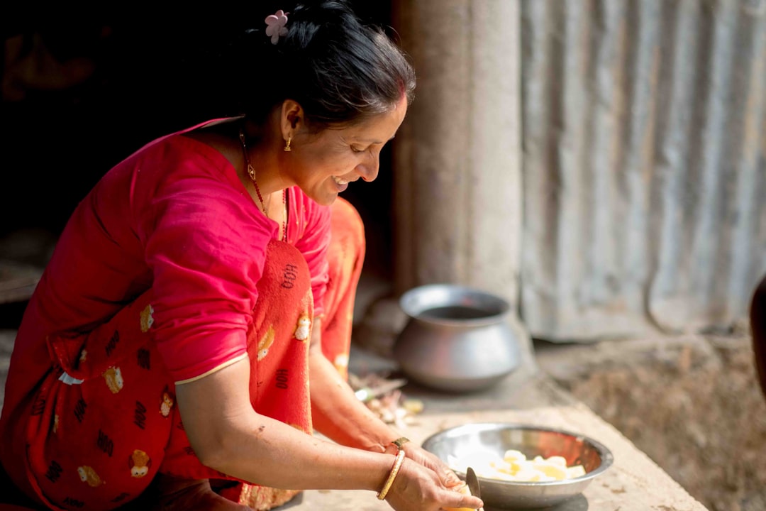A woman in an Indian kitchen measuring gluten-free flours to prepare homemade flatbread
