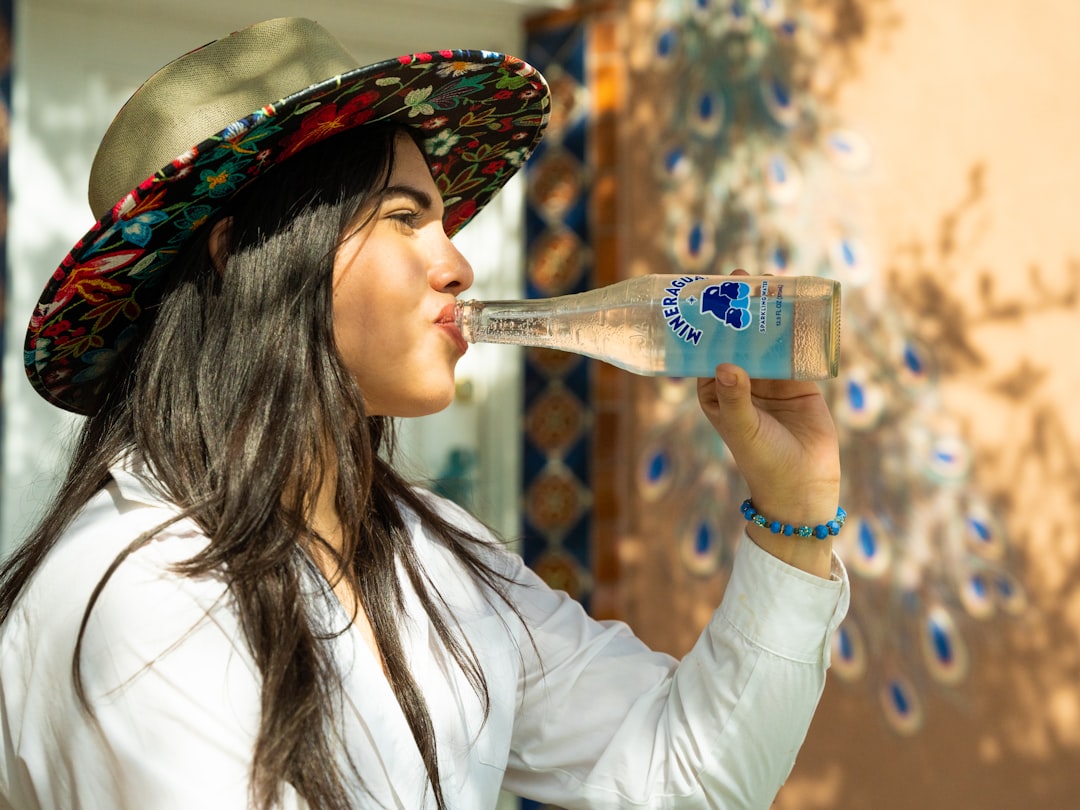 A young Indian woman drinking clean bottled water at a street market, protecting her gut health during monsoon season