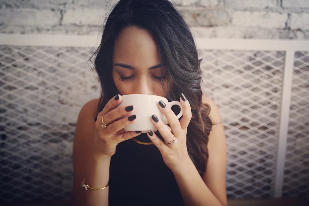 A woman practicing monsoon wellness by drinking warm tulsi ginger tea at home in India