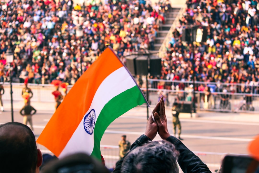 A woman in traditional dress holds the Indian tricolour at an Indian diaspora Independence Day ceremony abroad.