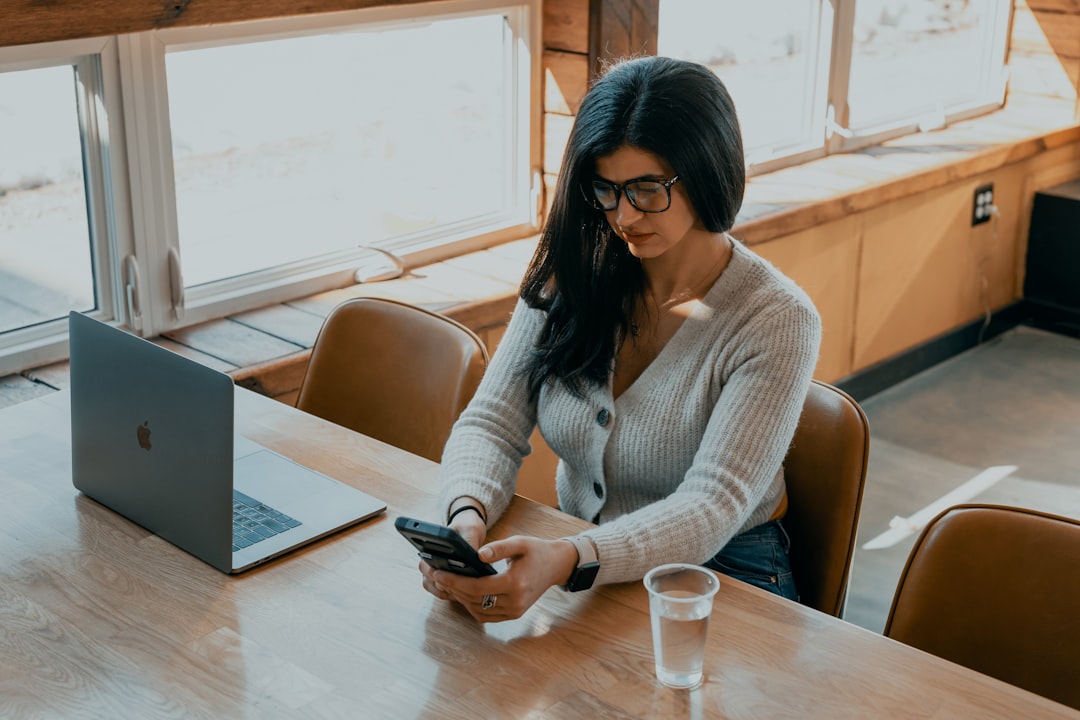 A young Indian professional woman reviewing mutual fund SIPs on her laptop at a modern home office desk