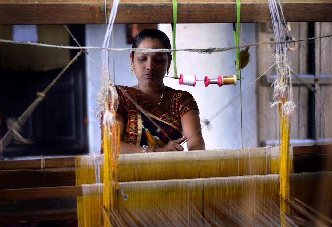 A skilled woman artisan weaving handwoven silk sarees on a traditional loom in India