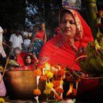 A woman devotee taking part in Janmashtami celebrations at a lit temple in Mathura at midnight