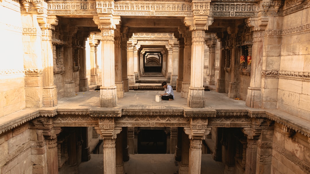 A woman descends the intricate stone steps of one of India's ancient stepwells in Rajasthan in golden morning light