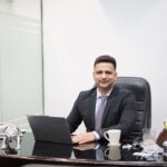 A focused Indian professional reviews REITs in India unit statements at a modern office desk