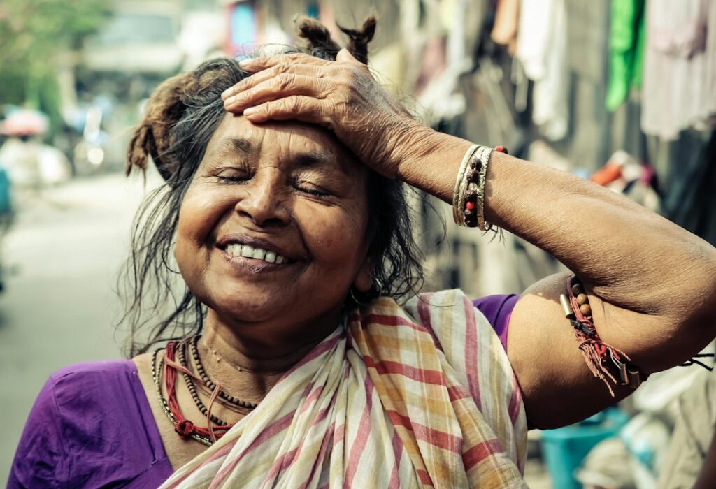 A young Indian woman applying ubtan paste to her face as part of her traditional skincare ritual