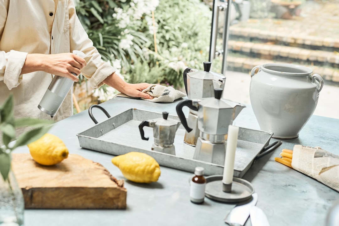 A woman in an Indian kitchen assembling a zero-chemical cleaning kit with lemon, baking soda, and vinegar on the counter