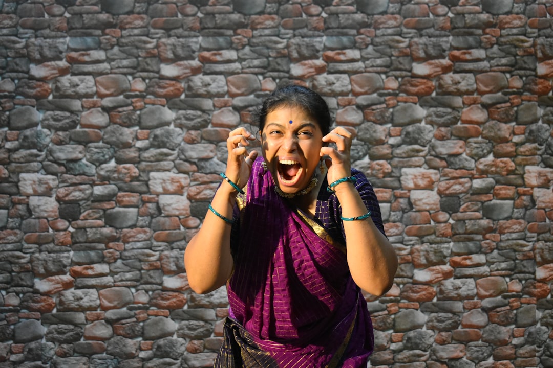 A female vocalist performing Carnatic music on stage at a South Indian concert hall