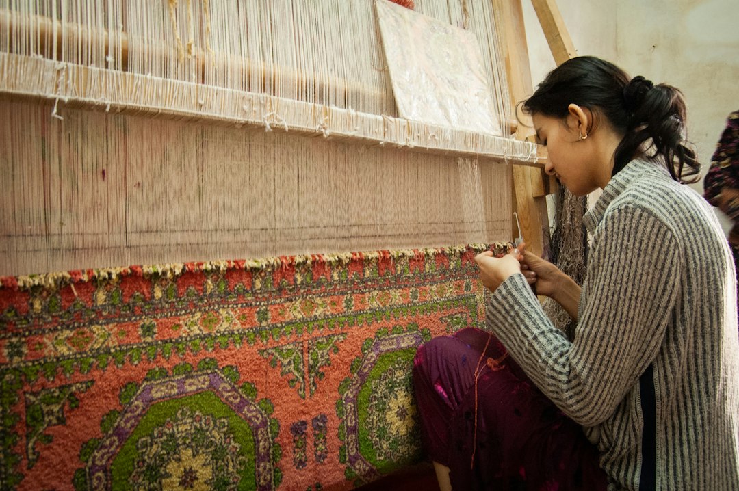 A weaver at her loom building handloom inventory ahead of the festive season in a traditional Indian weaving village.
