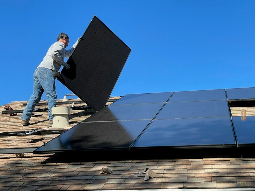 Homeowner inspecting a rooftop solar panel installation on an Indian house